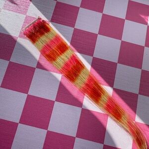 Blonde pink and orange raccoon tail extension